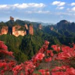 1. 丹霞山主峰 - Main Peak of the Mount Danxia: 每年春季，景区内的映山红连片绽放，与赤壁丹崖相映成辉。观丹霞日出，万丈光芒与丹霞群峰连成一片让人为之震撼。 In every spring, Sims Azalea blooms everywhere, which set off against the Red Danxia Cliff at the same time. Watching the sunrise on Mount Danxia, the infinite sunshine and groups of mountains linked together, which let people be shocked.